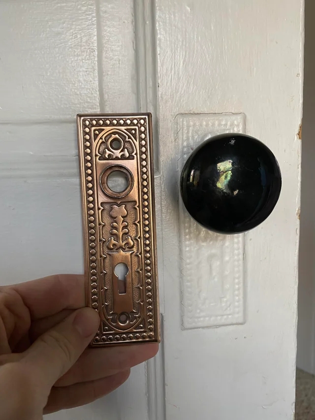 antique hardware held next to a painted doorknob