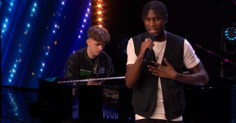 flintz singing with his eyes closed as taylor plays the piano behind him for their “britain’s got talent” audition.