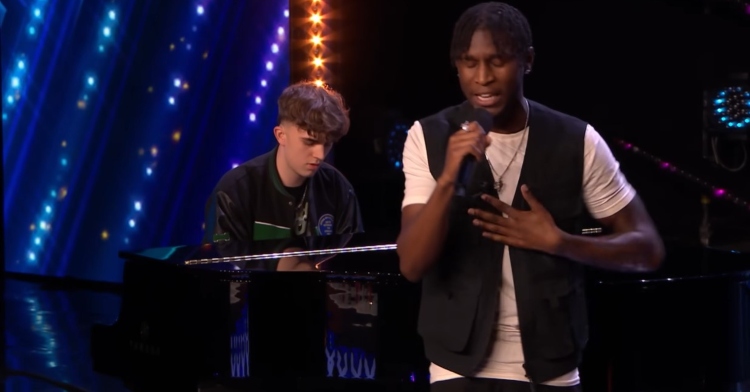 flintz singing with his eyes closed as taylor plays the piano behind him for their “britain’s got talent” audition.