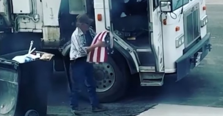 garbage collector and marine corps veteran, don gardener, carrying an american flag he pulled out of a trash can toward his truck so he can fold it.