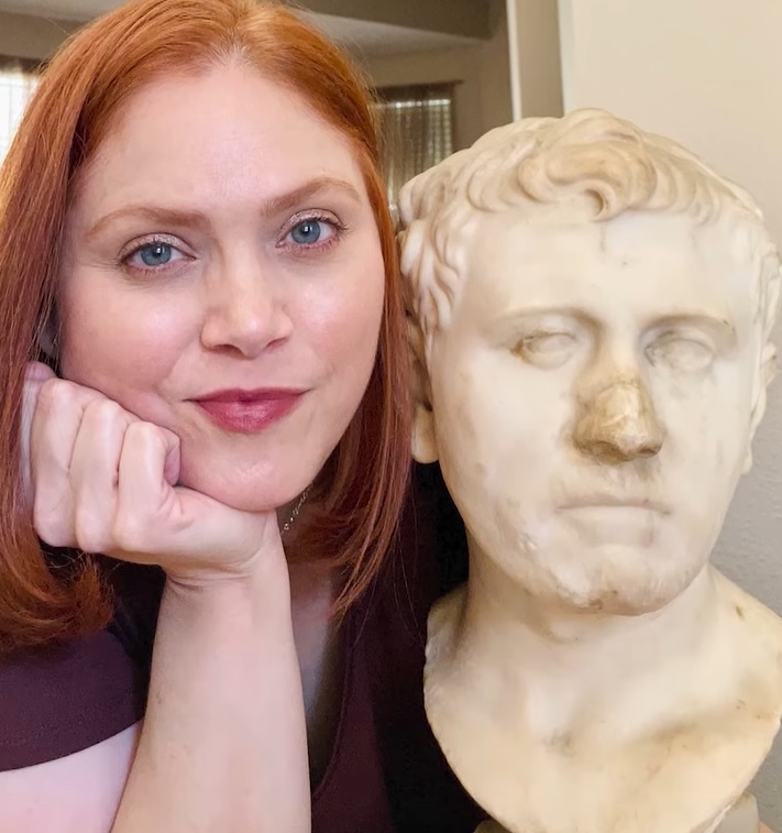 Laura Young posing next to the bust