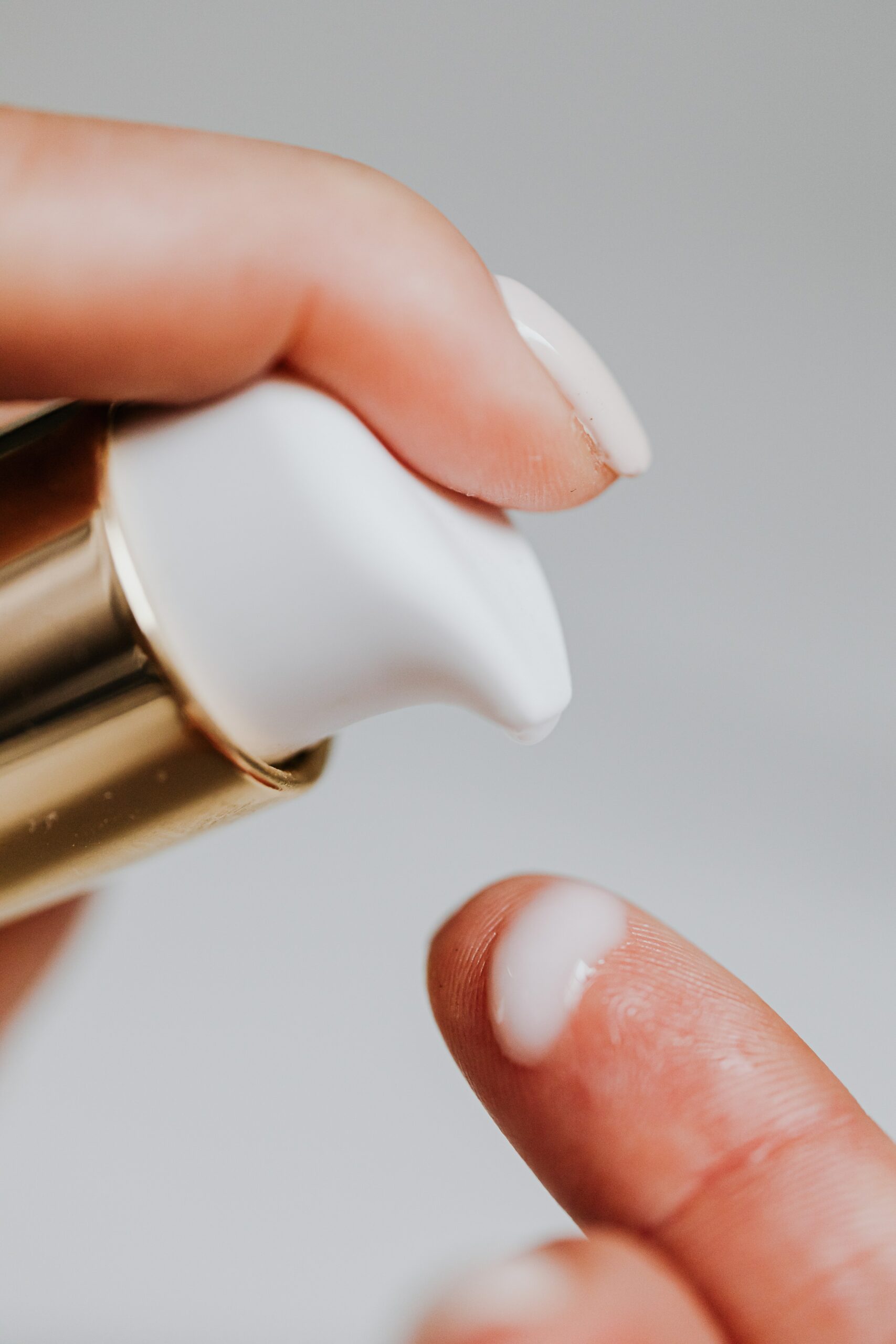 hand pouring some skin lotion into a finger