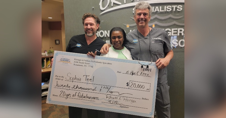 mike nelson, sophia teel, and ron risinger, smiling as they hold a giant check made out to sophia for $20,000.