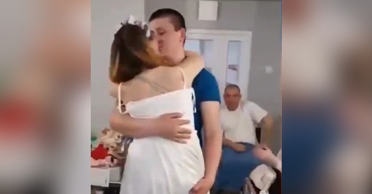 oksana balandina and viktor vasyliv kissing as they have their first dance at their wedding in a hospital in ukraine.