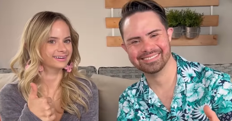 sofia jirau and chris gonzalez smiling as they sit on a couch and each give a thumbs up.