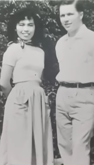 black and white photo of peggy yamaguchi and duane mann smiling outside.