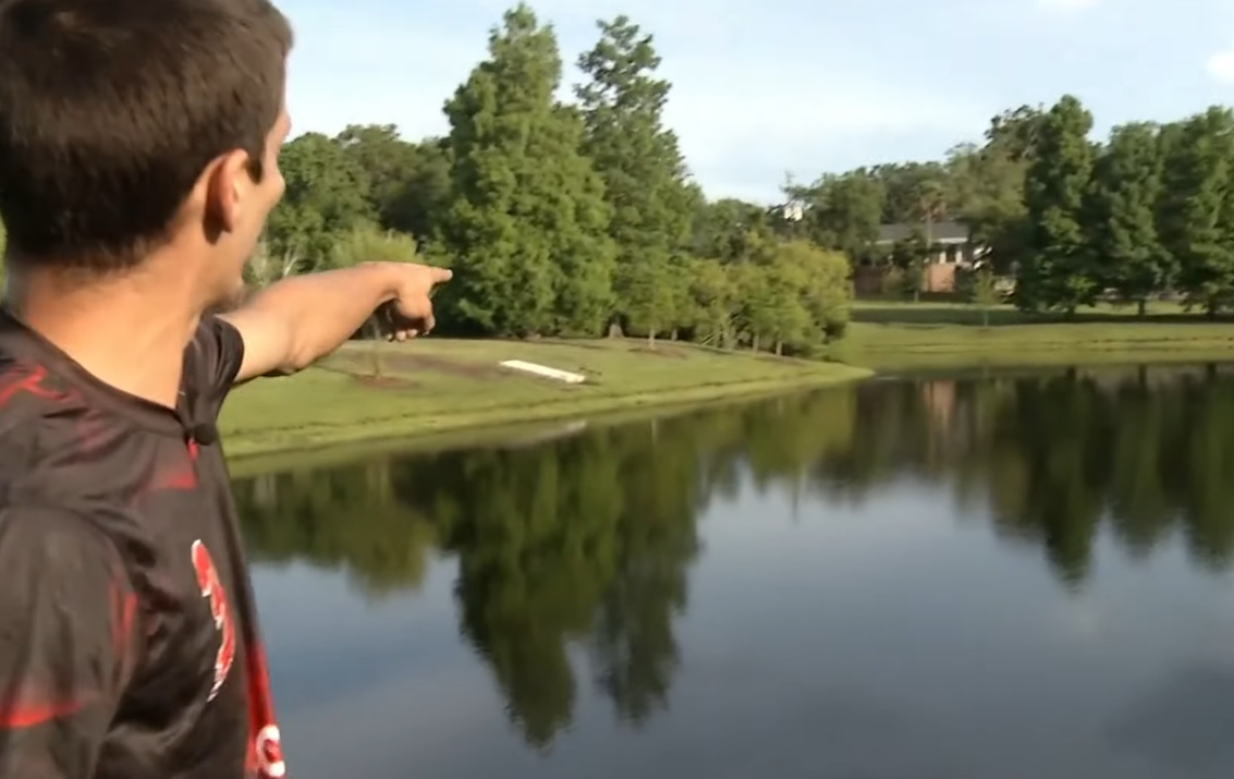 Sean Battles at Blue Cypress Park pointing at a pond.