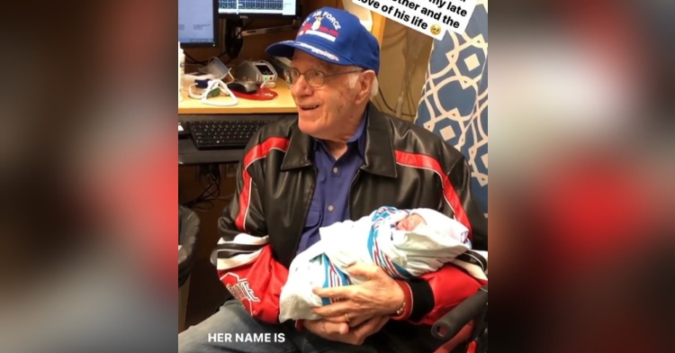 91 year old grandpa smiling as he holds his granddaughter, justine joanne.