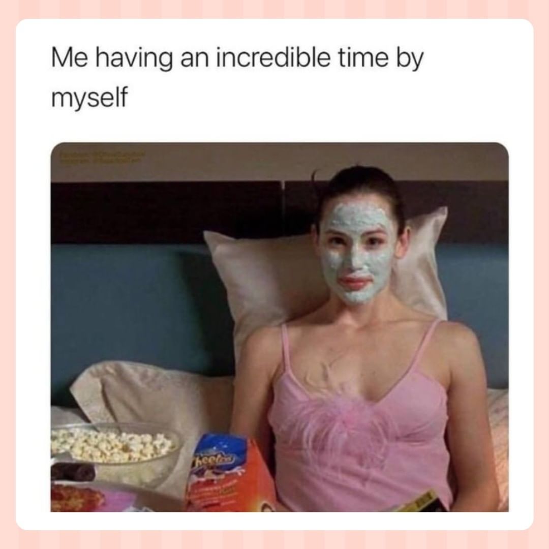 image of a woman sitting in bed with snacks and a skincare facemask on with the caption "me having an incredible time by myself"