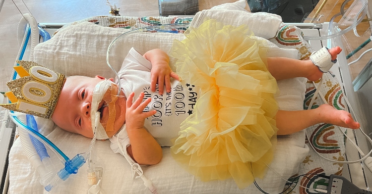 Everly Staub in the NICU wearing a crown that says "100"