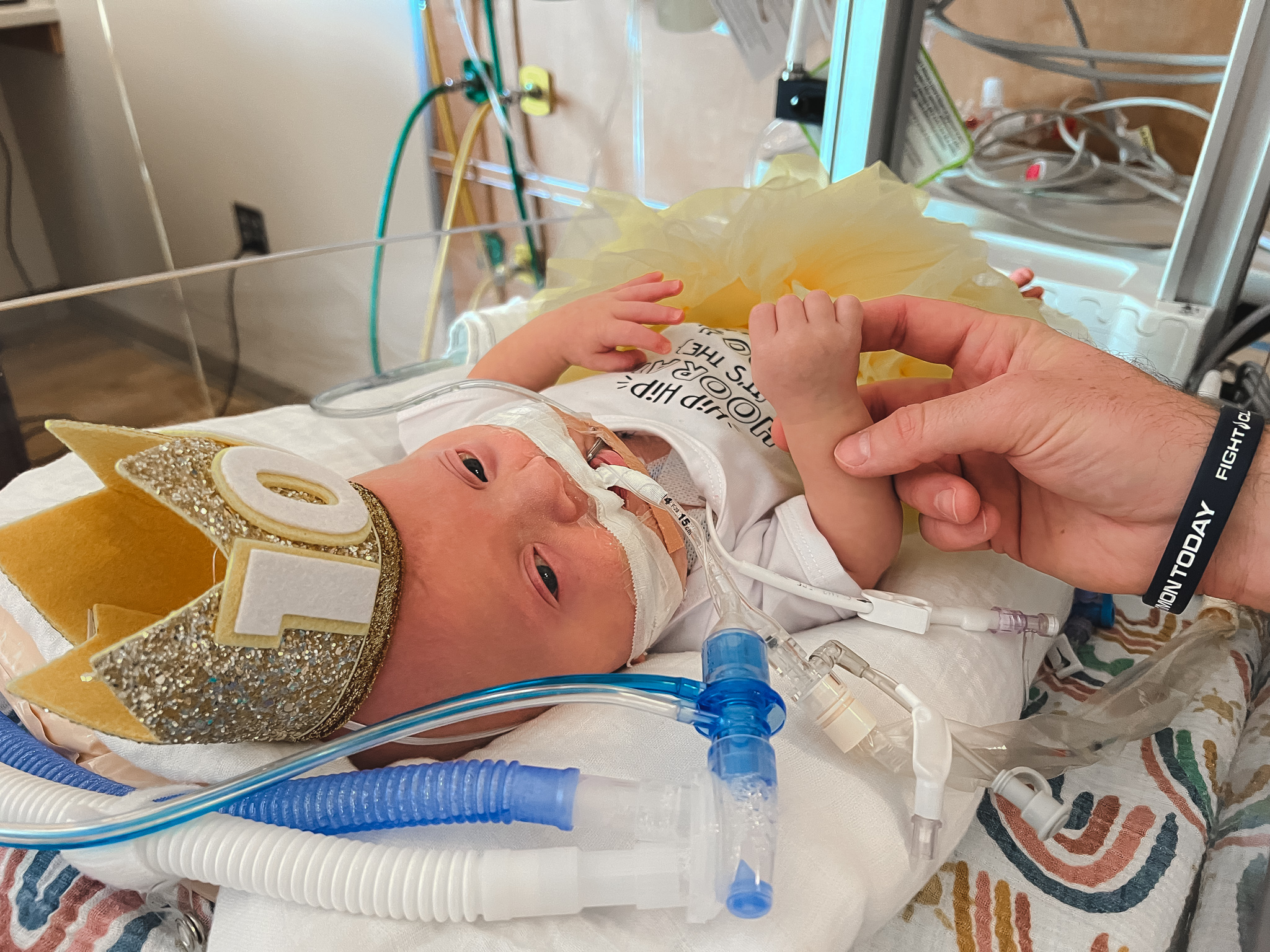Everly Staub in the NICU wearing a crown that says "100"