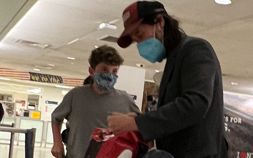 little boy and keanu reeves talking at the nyc airport.