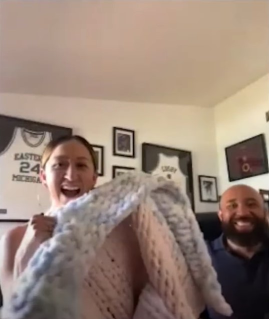 david amastae and candace countryman smiling as candace holds up the blanket angela got for their baby, luna.