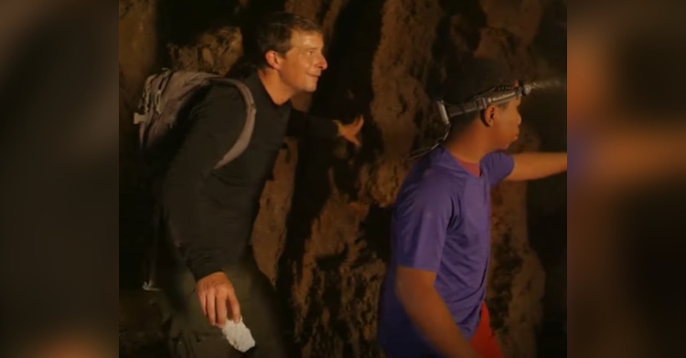 cameron leading bear grylls as they walk through an abandoned building.