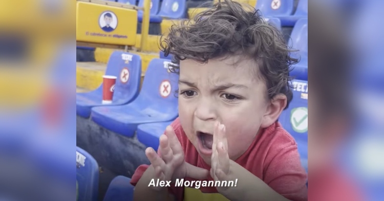 two year old luca placing his hands around his mouth as he cheers for alex morgan. the image is captioned with “alex morgannnn!”
