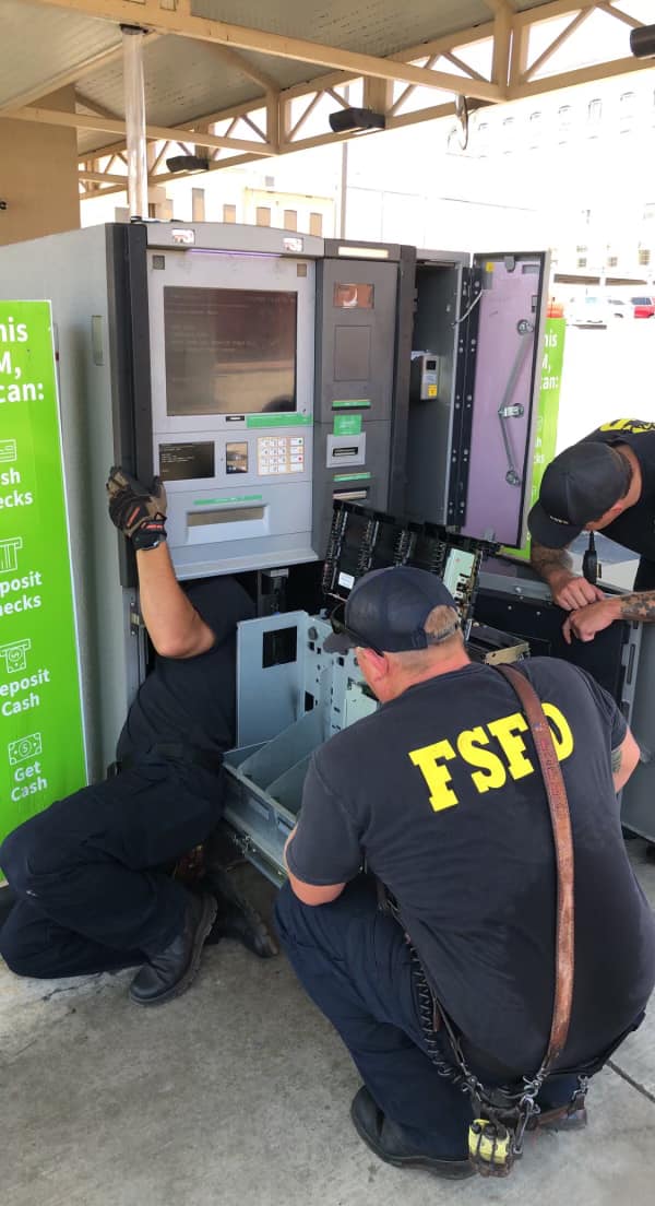 firefighters opening ATM machine to rescue kitten that was stuck inside.