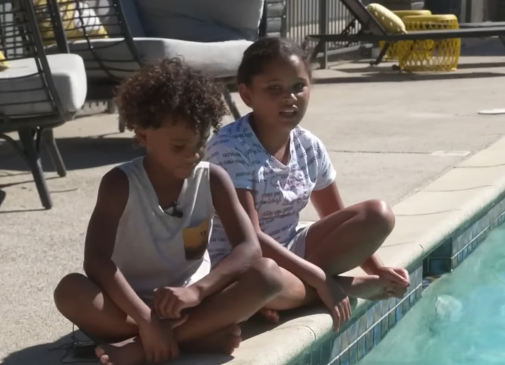 massiah browne and his aunt savannah sitting by a swimming pool.