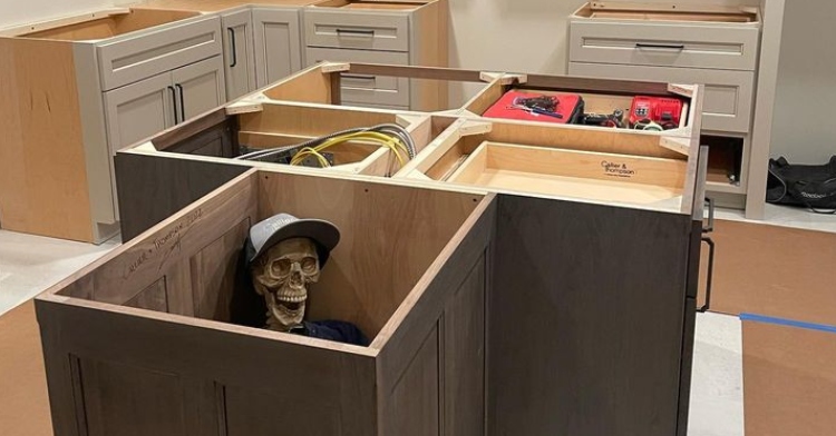 fake skeleton wearing clothes hidden inside kitchen cabinet