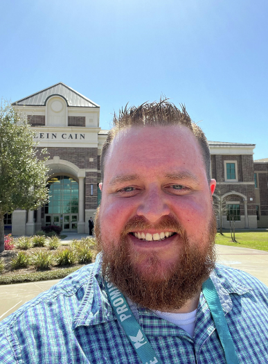 stephen hansell smiling for a selfie taken in front of klein middle school in texas.