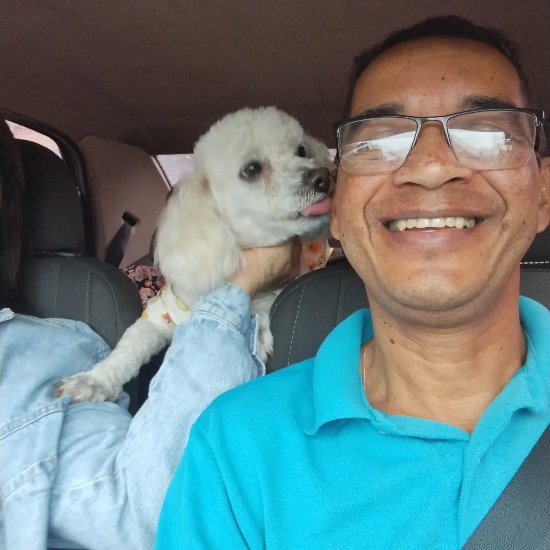 Hamilton Taurino in car with white fluffy dog giving him kisses