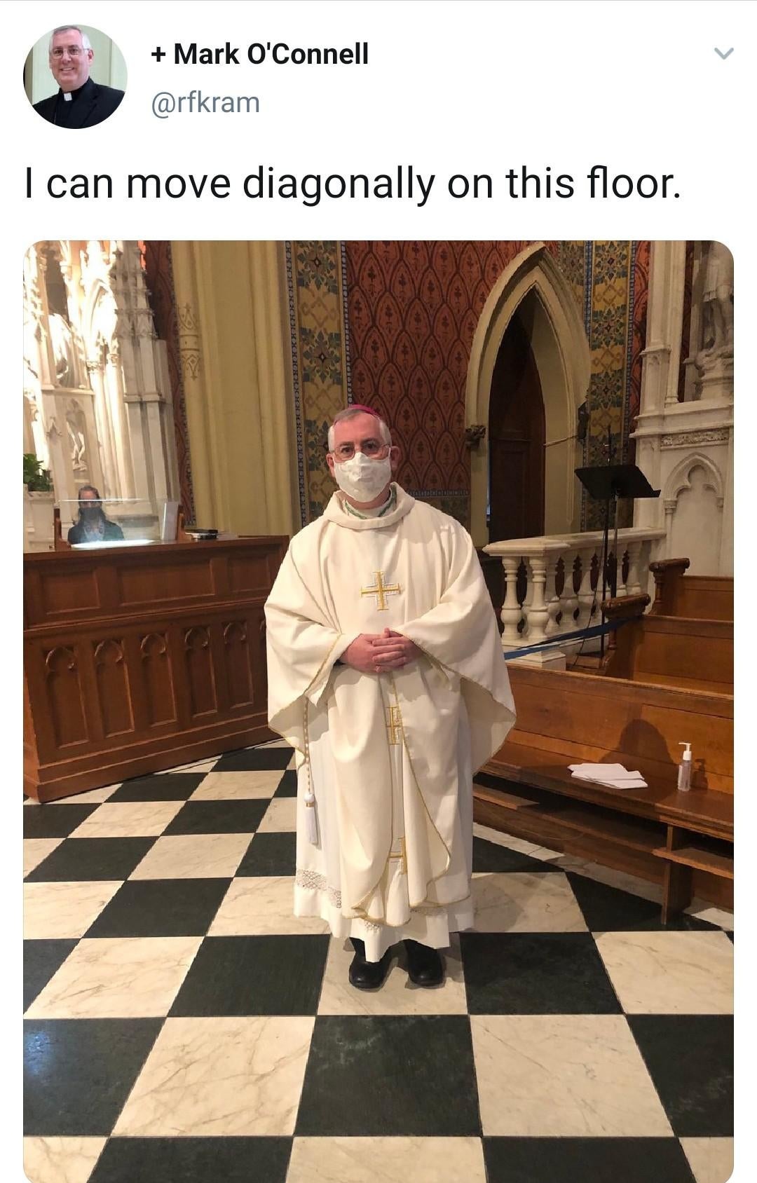 a tweet by a priest named Mark O'Connell that says "I can move diagonally on this floor." and a picture of him with him standing on a floor that looks like a chess board.