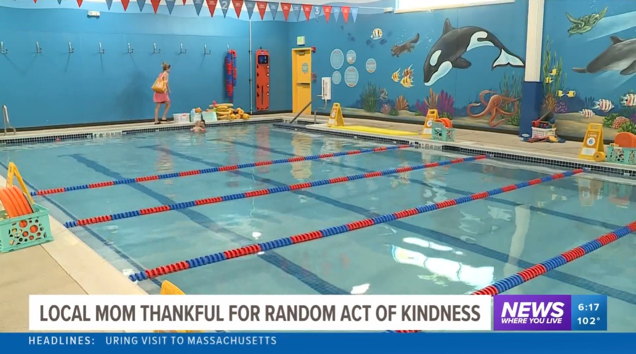 view of a pool inside goldfish swim school in bentonville, arkansas as seen on a news channel. the bottom of the image is the title of the news story: "local mom thankful for random act of kindness."