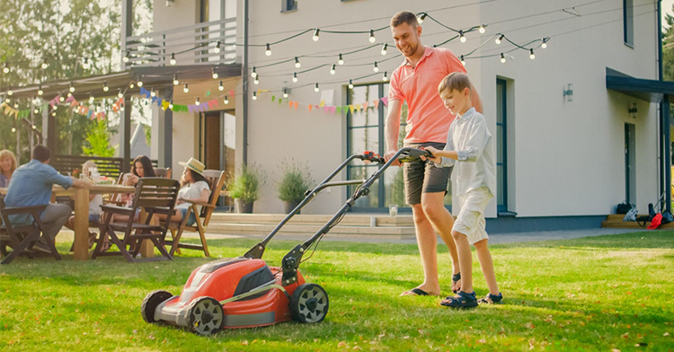 father and son pushing lawnmower