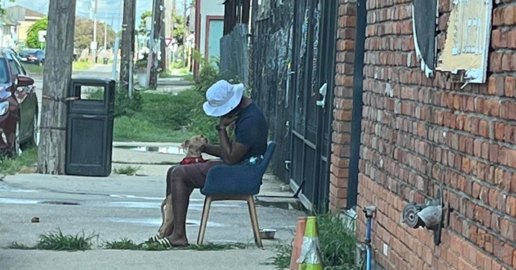 New Orleans teacher sitting on a chair outside of a rescue center with his puppy.