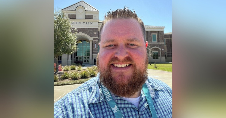 stephen hansell smiling for a selfie taken in front of klein middle school in texas.