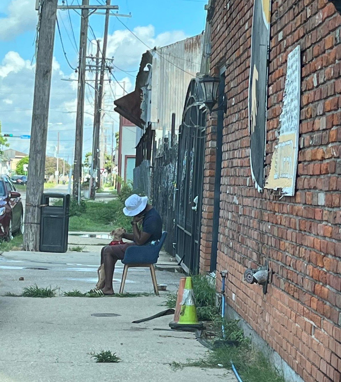 New Orleans teacher sitting on a chair outside of a rescue center with his puppy.