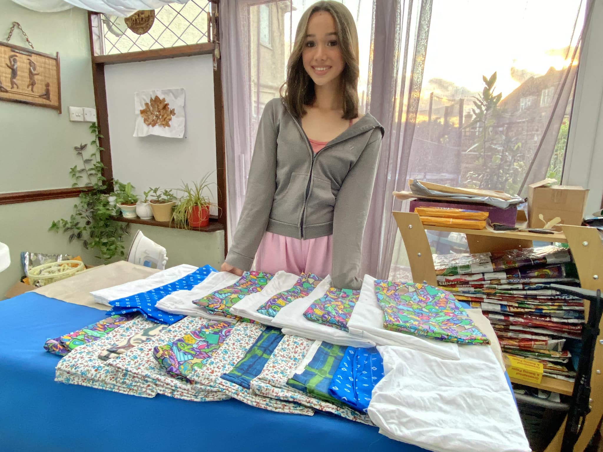 Alyssa smiling with a table full of fabric.