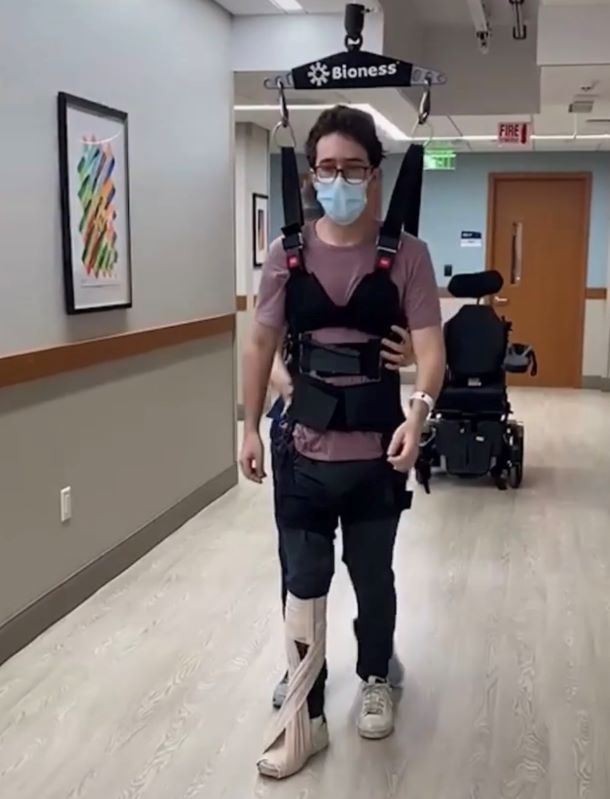 Chase Friedman walking in harness during therapy.