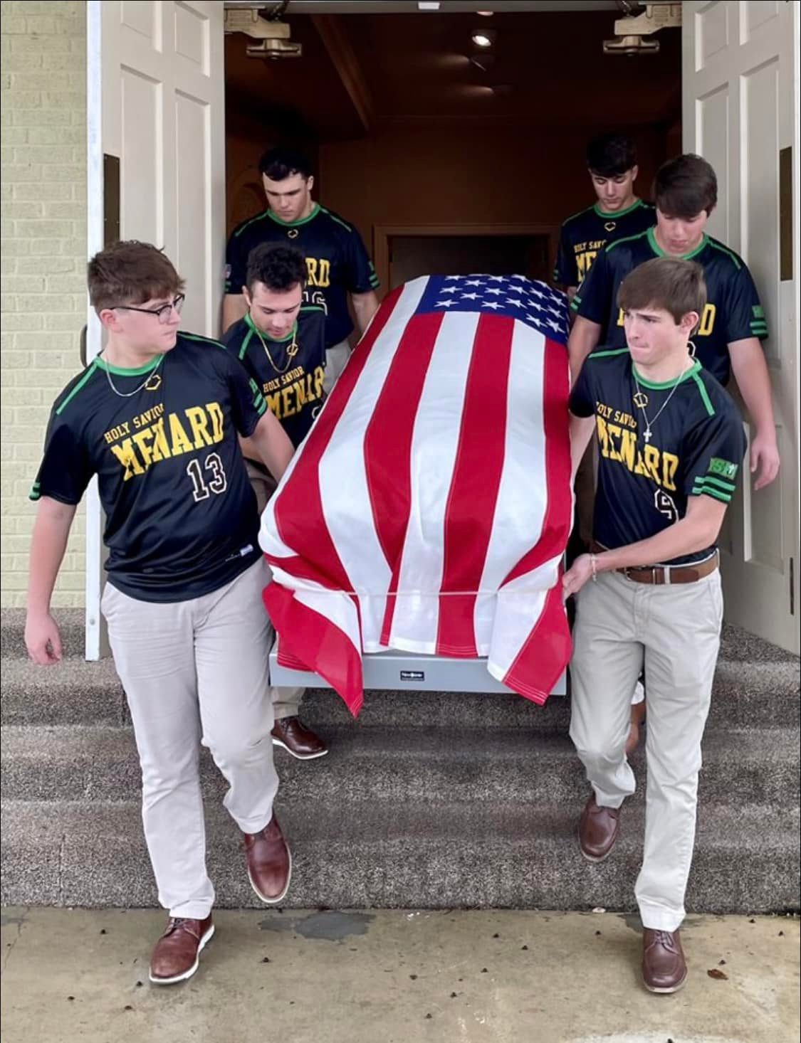 Menard High School baseball players carry coffin of veteran Ralph Lambert.