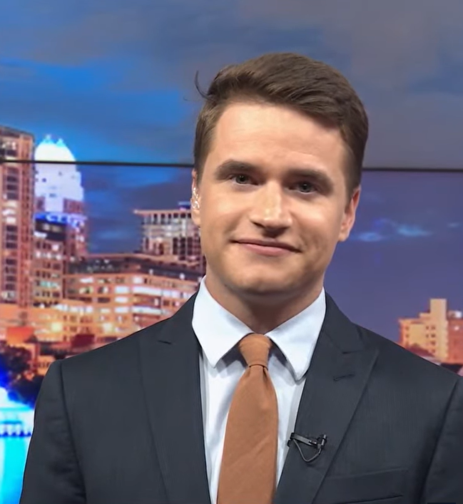 Closeup of Meteorologist Ian Cassette smiling in the studio while wearing a suit and tie.