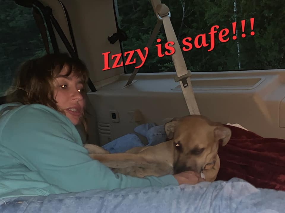 Meagan Glesser and Izzy the dog laying in a vehicle after she was finally found. The image is captioned "Izzy is safe!!!"