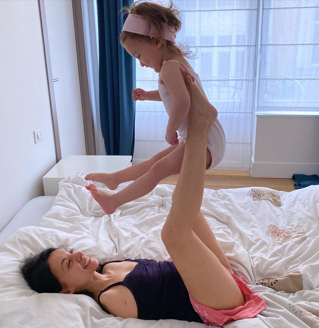 Sarah Talbi plays with her daughter Lilia in bed
