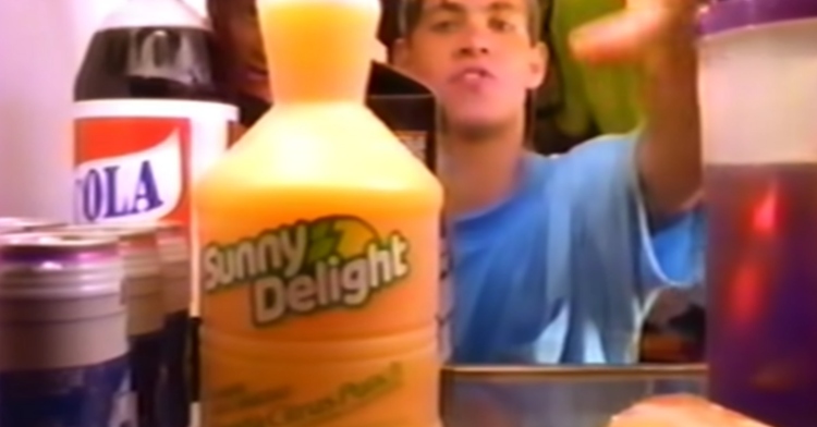 still from 90s commercial for Sunny Delight. Teen reaches inside fridge and chooses Sunny D.