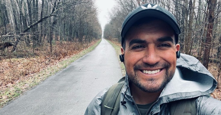 Travis Snyder smiles as he takes a selfie while hiking around lake Michigan.