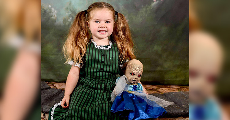 Briar smiling with her doll Creepy Chloe at Disney.