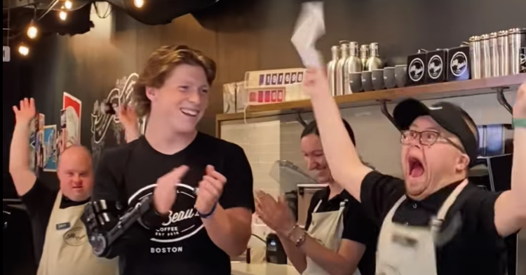 coffee shop employee jumping with joy after receiving his first paycheck.