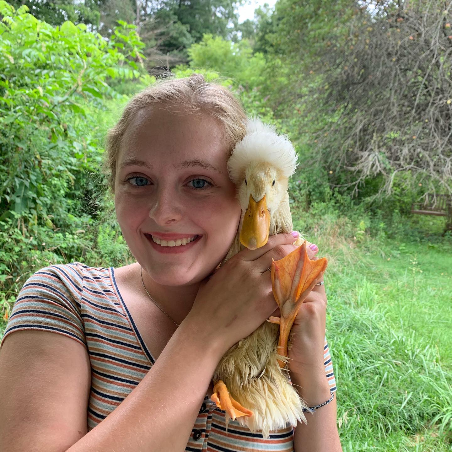 alexa smiling as she holds up a duck next to her face. they're both 