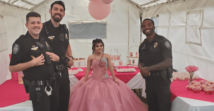 officers Matthews, King and Johnson standing and smiling right next to the quinceanera who is also smiling and wearing a big pink dress