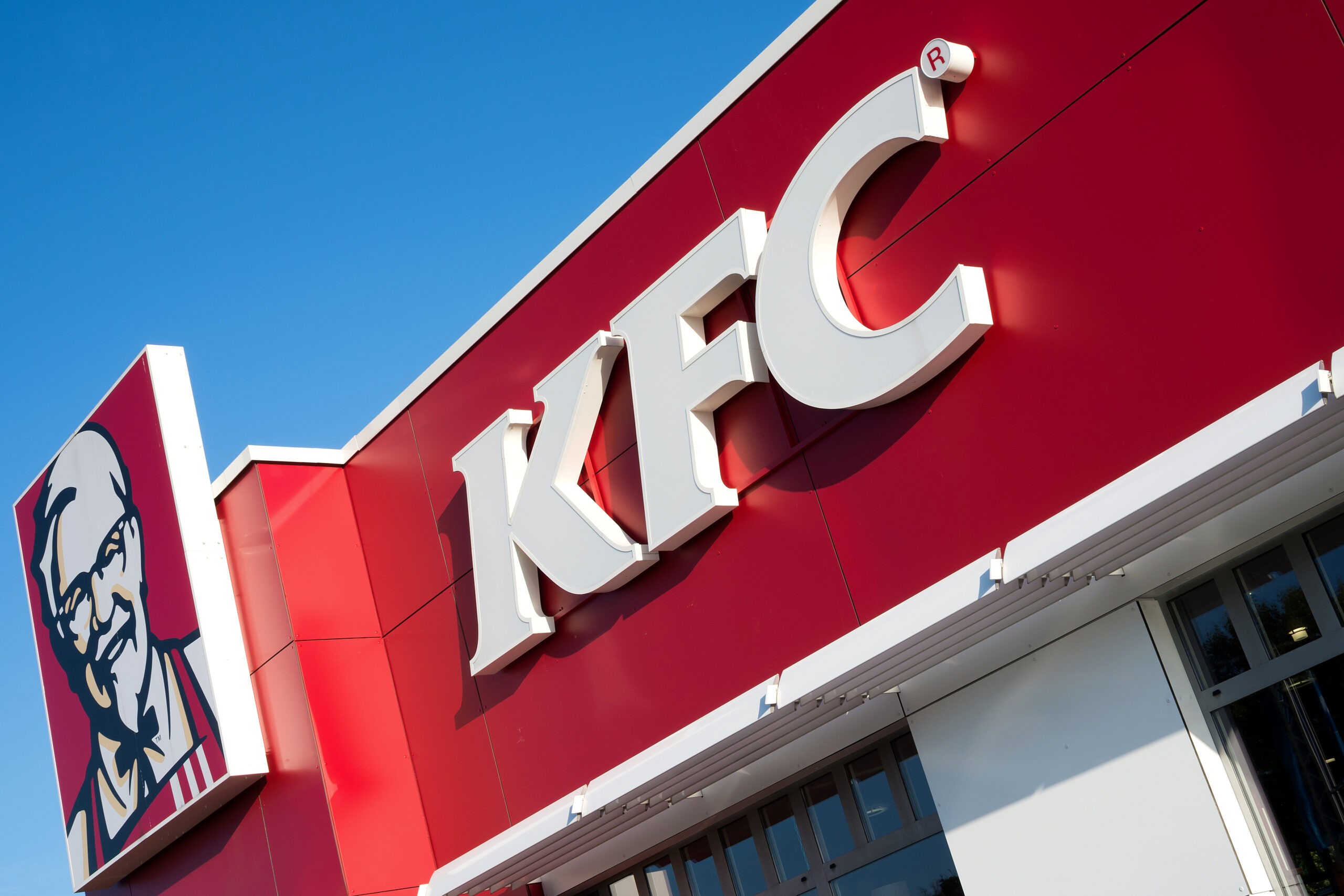 a picture of a KFC restaurant sign taken from the outside of the establishment.