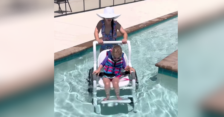 Katrina Placzek pushing Dallas wheelchair into the wheelchair-accessible pool.