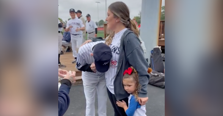 laura decker holding her daughter on one side and hugging her grandpa who is crying on the other side.