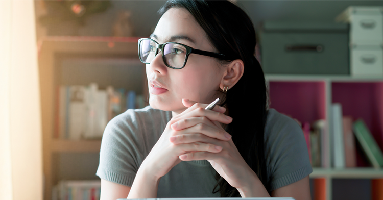 woman wearing glasses and looking thoughtfully off to the side