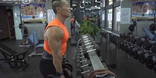 Xinmin lifting weights at a gym.