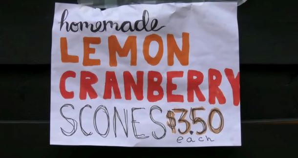 A handmade sign advertising scones that reads "homemade lemon cranberry scones. $3.50 each"