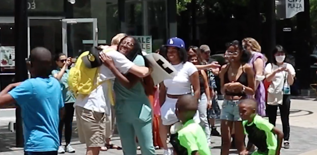 Zach hugging a woman who is smiling in the middle of downtown greenville