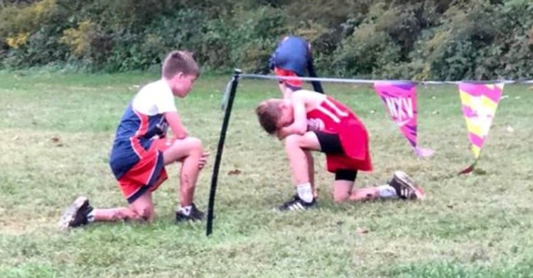 Cooper Kohanski kneels to check on fellow runner Andrew Hawkinson